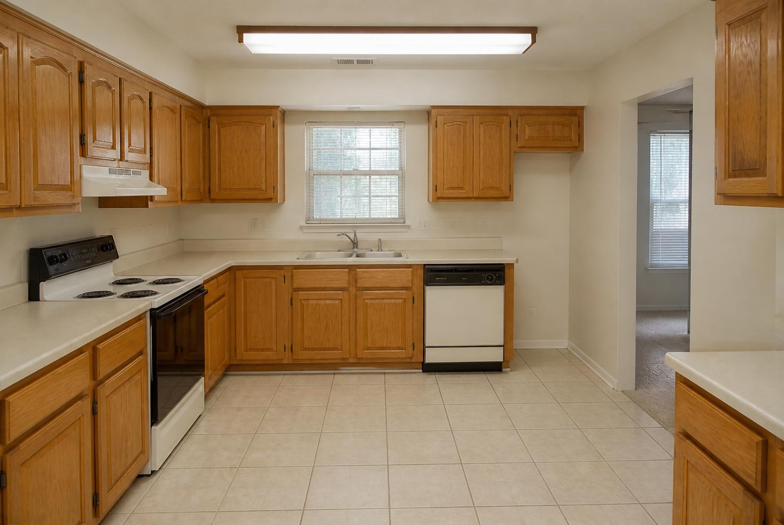 Dated kitchen before renovation with oak cabinets and laminate counters